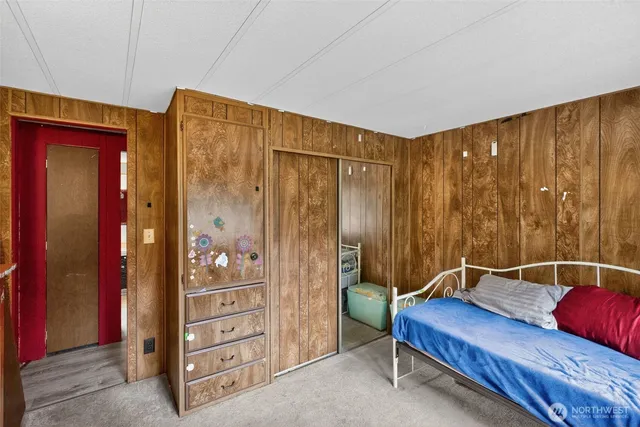 a bedroom with a bed and a flat tv screen on wall