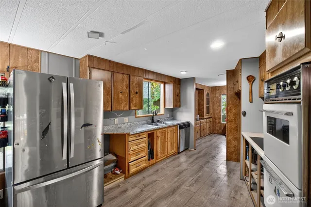a kitchen with stainless steel appliances a refrigerator a stove a sink and a refrigerator