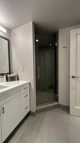 a bathroom with a granite countertop sink toilet and shower