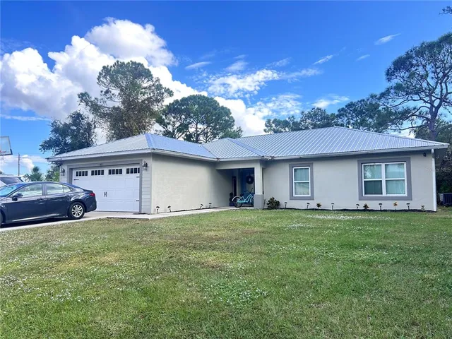 a view of a house with a yard and a garage