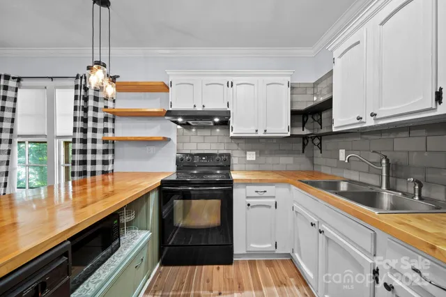 a kitchen with stainless steel appliances granite countertop a refrigerator a sink dishwasher a stove and white countertops with wooden floor