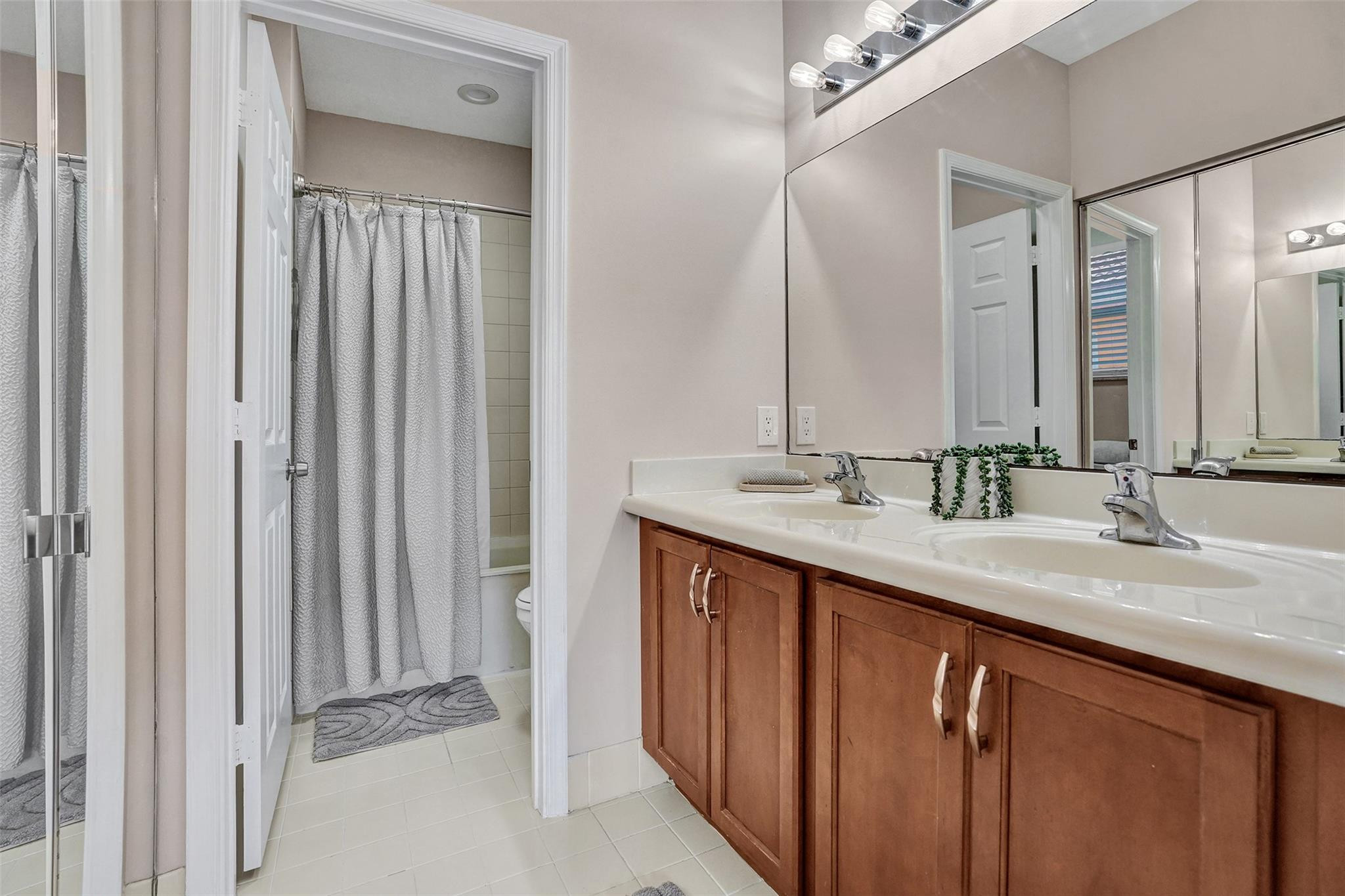 1825 Sonrisa Street Riviera Beach, FL 33404 - Photo 21 of 50 a bathroom with a double vanity sink and a mirror