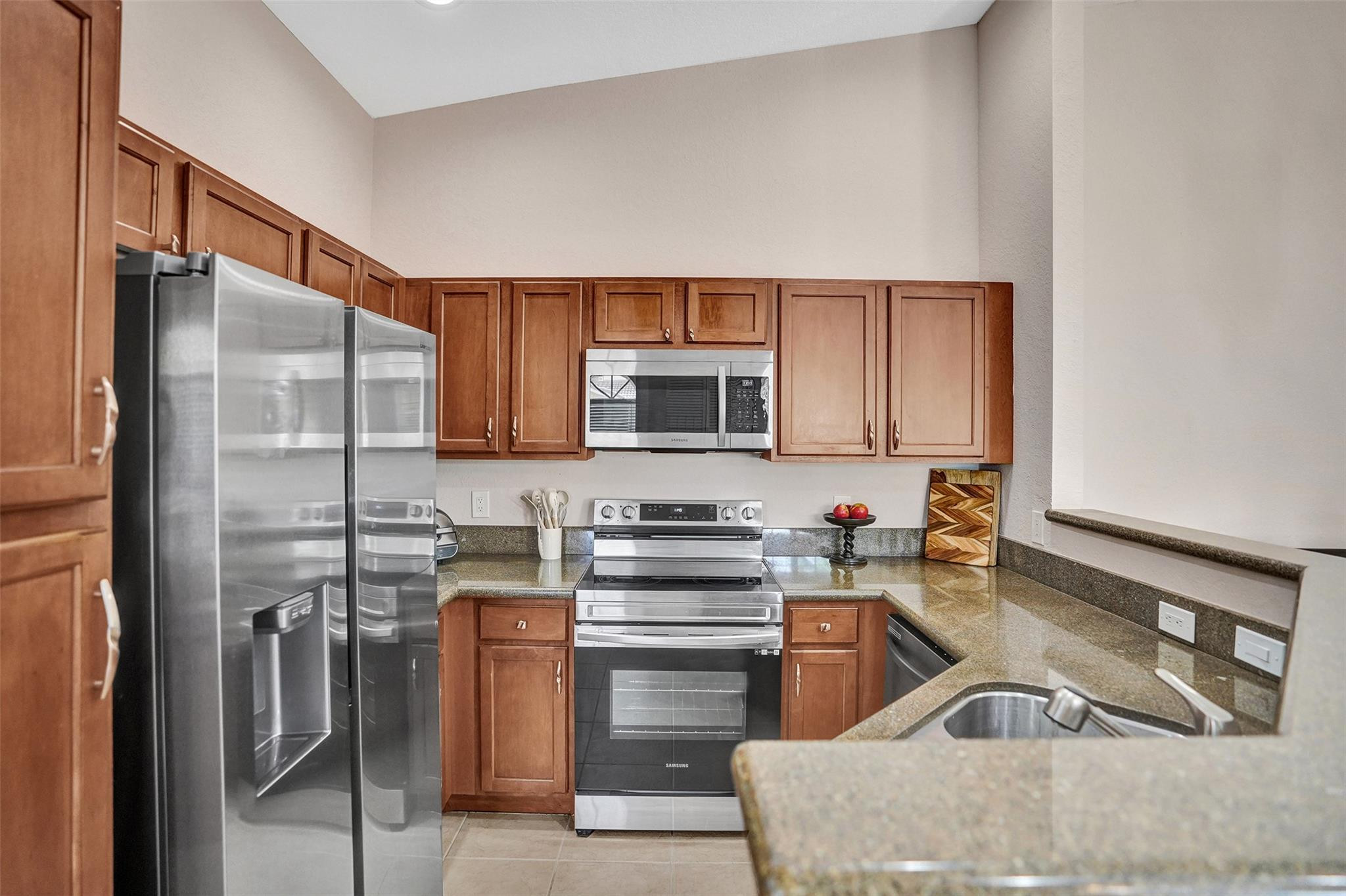 1825 Sonrisa Street Riviera Beach, FL 33404 - Photo 3 of 50 a kitchen with stainless steel appliances granite countertop a stove a sink and a refrigerator
