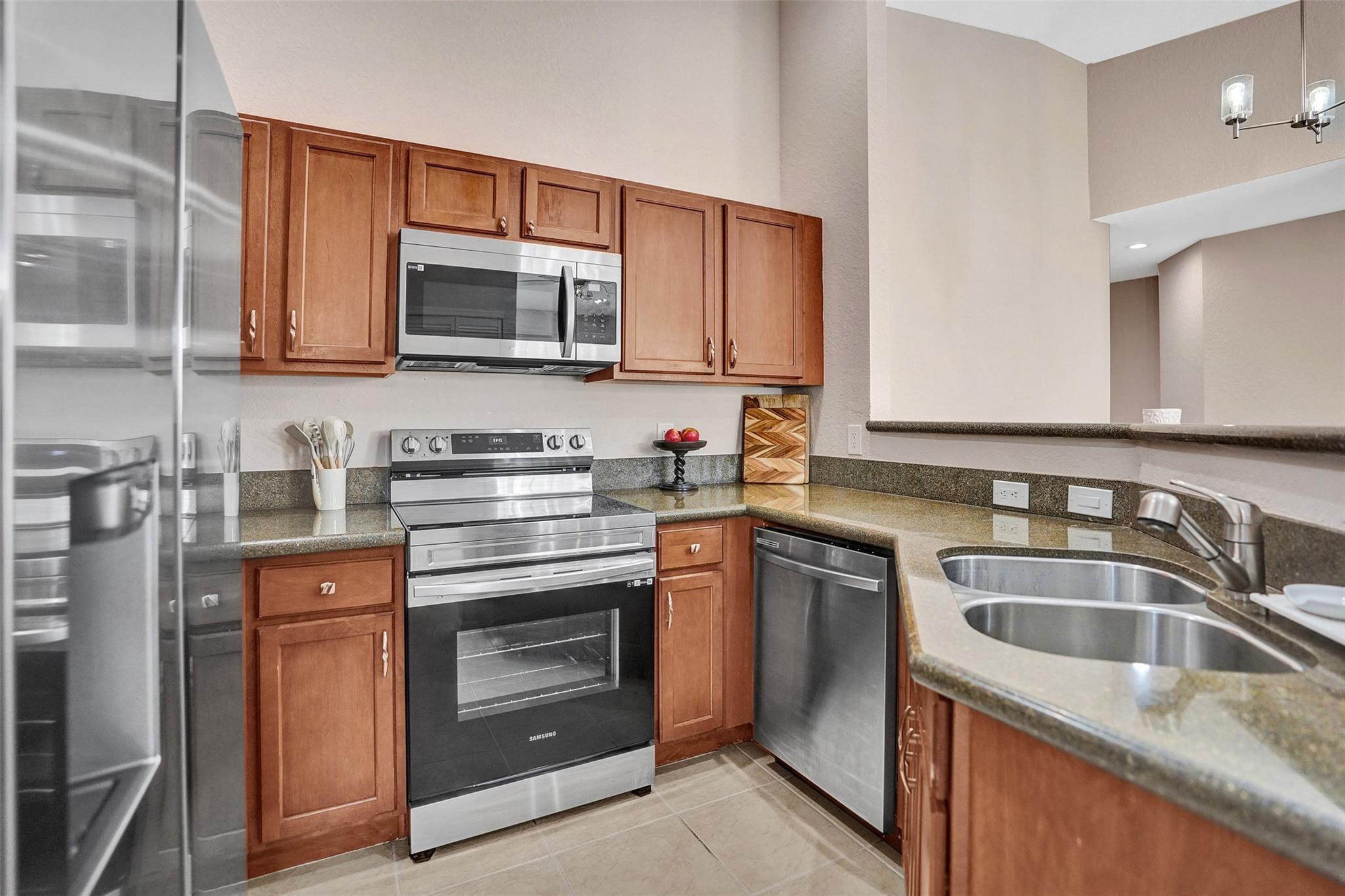 1825 Sonrisa Street Riviera Beach, FL 33404 - Photo 4 of 50 a kitchen with stainless steel appliances granite countertop a sink stove and microwave
