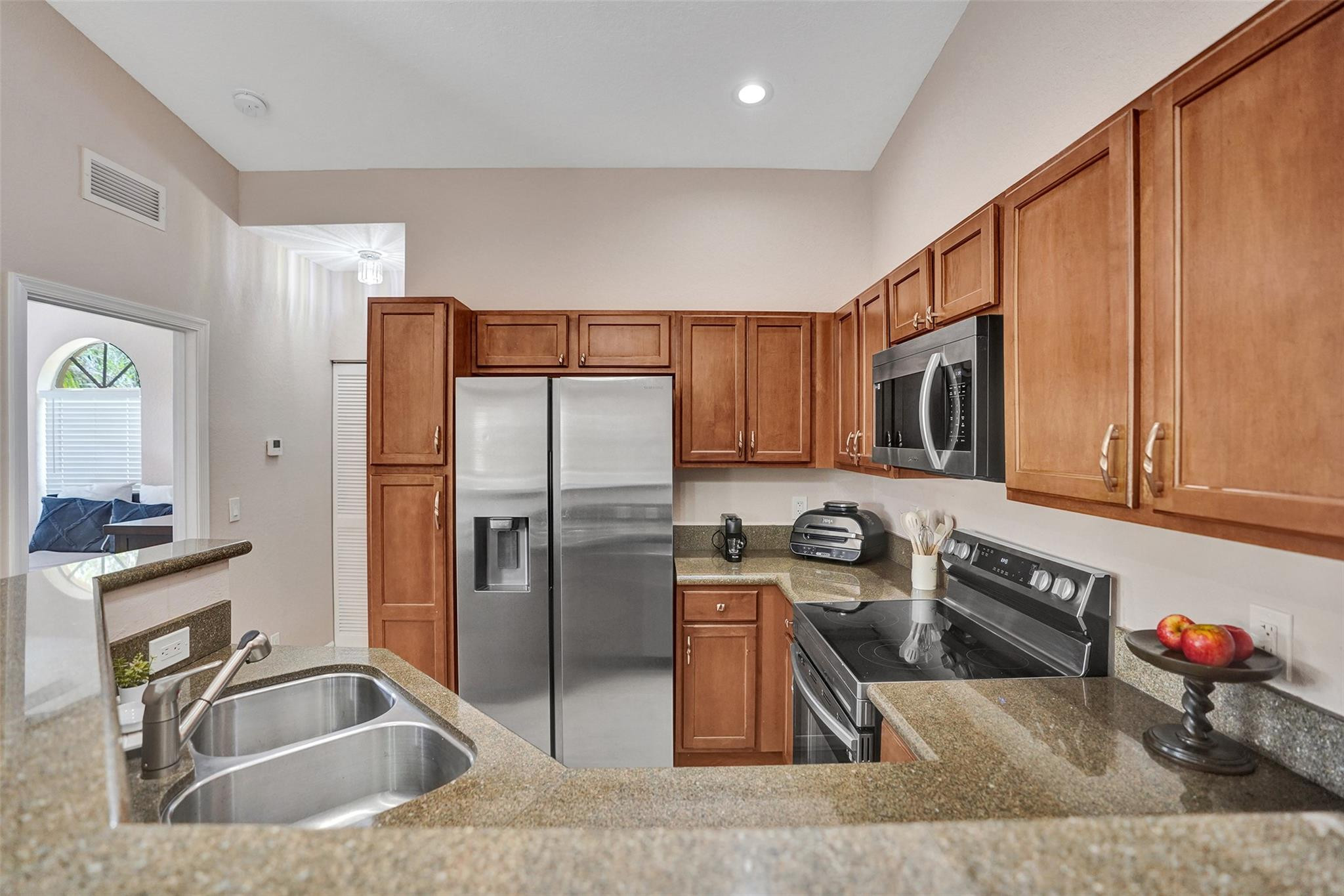 1825 Sonrisa Street Riviera Beach, FL 33404 - Photo 6 of 50 a kitchen with stainless steel appliances granite countertop a sink refrigerator and microwave
