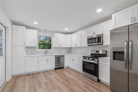 a kitchen with granite countertop a sink stainless steel appliances and cabinets
