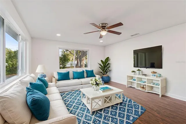 a living room with furniture a flat screen tv and a large window