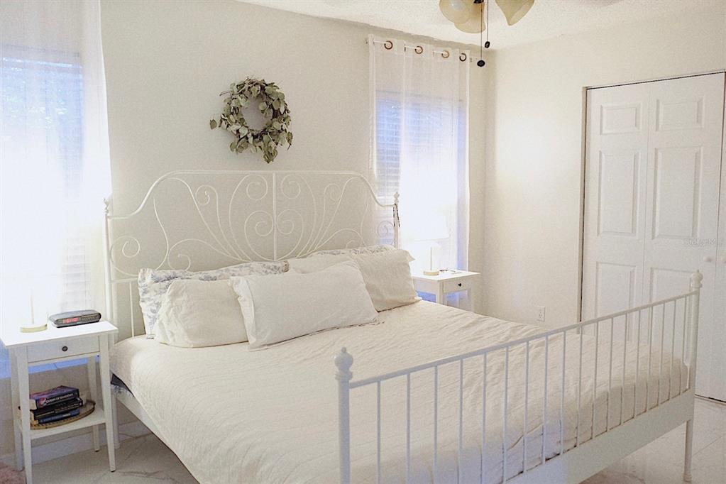 10659 Windsor Court Orlando, FL 32821 - Photo 12 of 15 a bedroom with a white bed and a chandelier