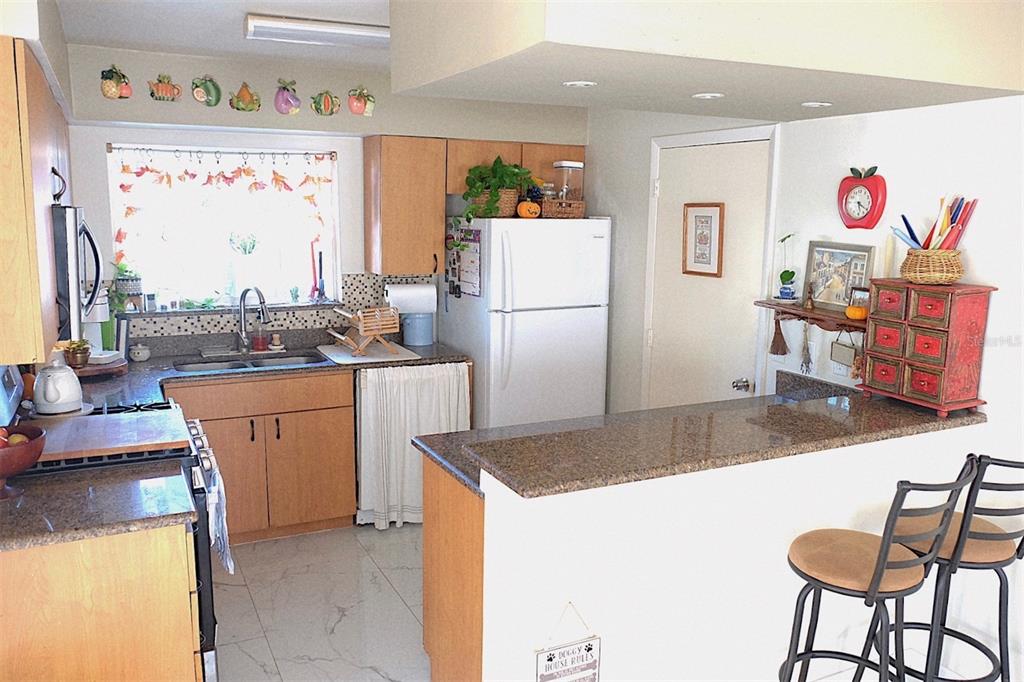 10659 Windsor Court Orlando, FL 32821 - Photo 2 of 15 a kitchen with refrigerator and chairs
