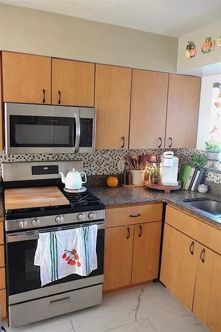 a kitchen with stainless steel appliances a stove and a microwave