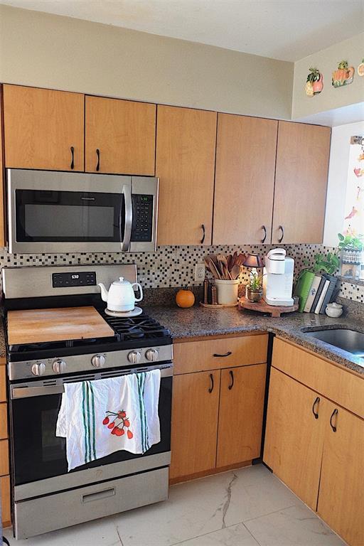 10659 Windsor Court Orlando, FL 32821 - Photo 3 of 15 a kitchen with stainless steel appliances a stove and a microwave