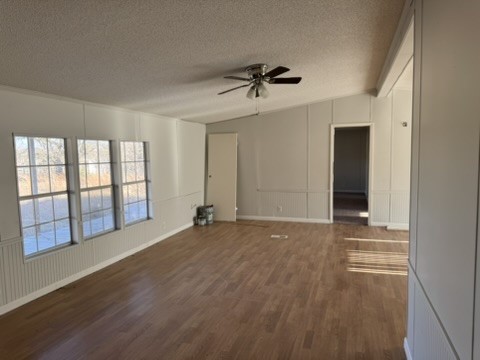 3035 County Road 255 Georgetown, TX 78633 - Photo 15 of 23 Unfurnished living room with dark wood-type flooring, a decorative wall, and a ceiling fan