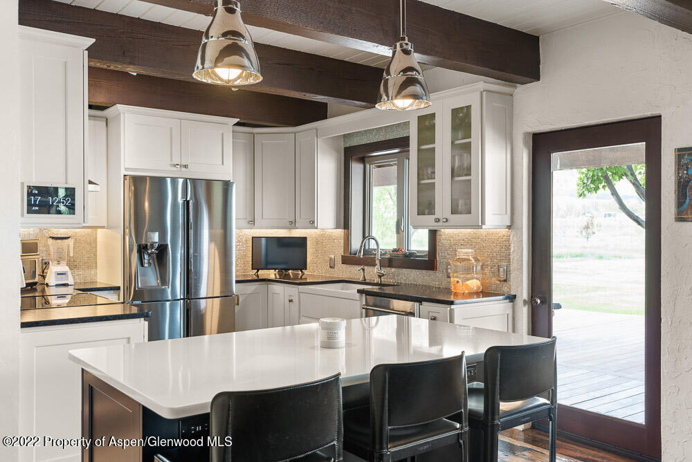 2459 Emma Road Basalt, CO 81621 - Photo 6 of 31 a kitchen with refrigerator cabinets dining table and chairs