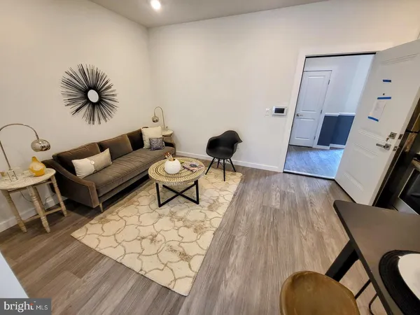 a living room with furniture and wooden floor