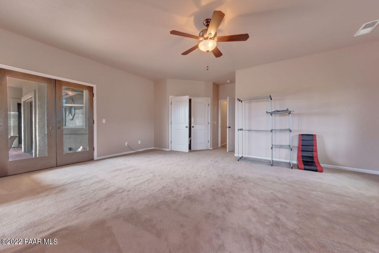 5755 West Rambling Road Prescott, AZ 86305 - Photo 10 of 22 an empty room with chandelier fan and windows