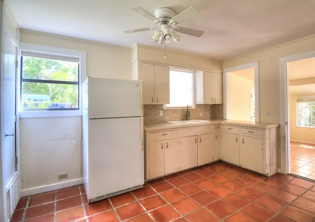 a kitchen with a refrigerator a sink and dishwasher with a large window