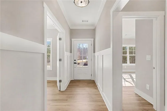 a view of a hallway with wooden floor and closet