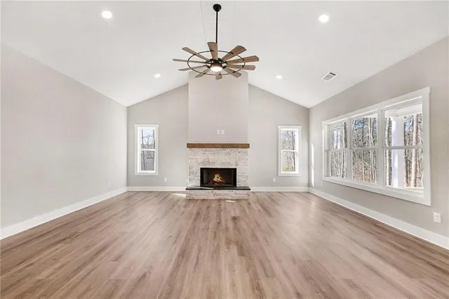 a view of an empty room with a window and fireplace