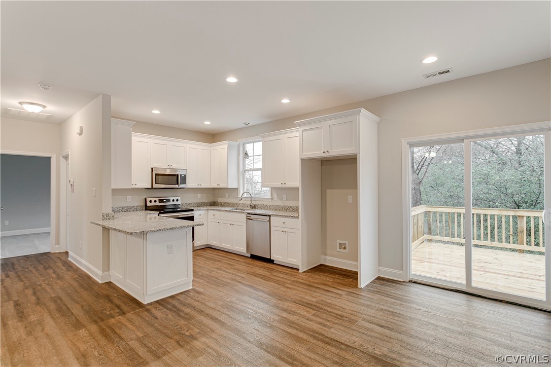123 Carter Road Cumberland, VA 23040 - Photo 8 of 25 The bright beautiful kitchen offers custom cabinets, recessed lighting, Samsung stainless steel appliances, gorgeous granite countertops, LVP flooring, and brushed nickel hardware and fixtures.
