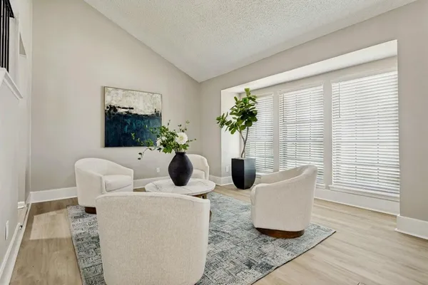 a living room with couches and a potted plant on a table