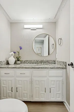 a bathroom with a granite countertop toilet sink and vanity