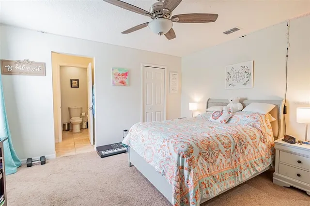 a bedroom with a bed and a ceiling fan