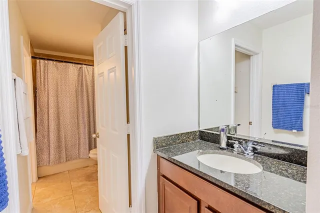 a bathroom with a granite countertop sink and a mirror