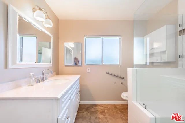 a bathroom with a sink a toilet and a mirror