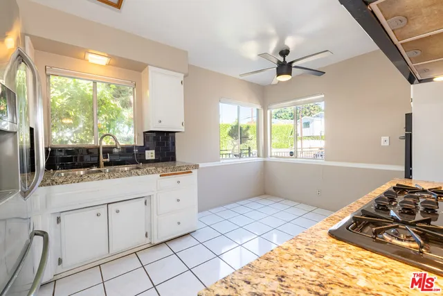 a kitchen with granite countertop a stove a sink and a granite counter tops