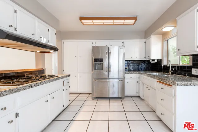 a kitchen with stainless steel appliances granite countertop a stove a sink and a refrigerator