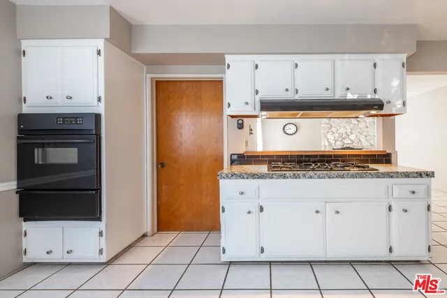 a kitchen with white cabinets and appliances