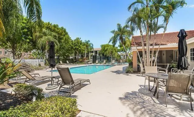 a living room with furniture a large window and a potted plant