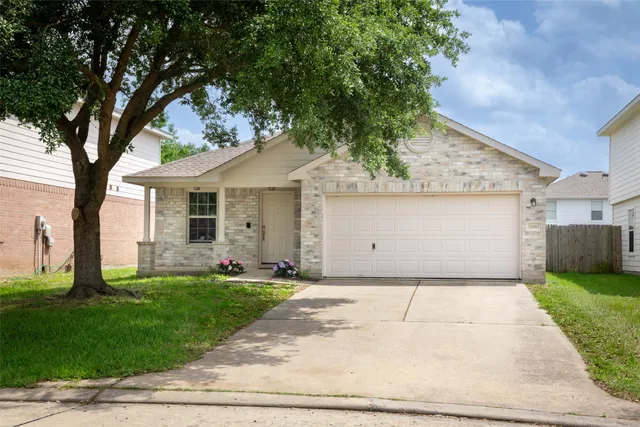 a front view of a house with a garden and trees