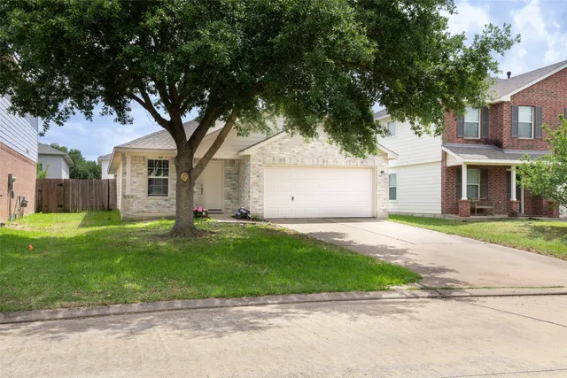 a front view of a house with a garden and trees