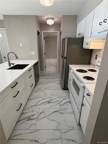 a kitchen with granite countertop a sink stove and refrigerator