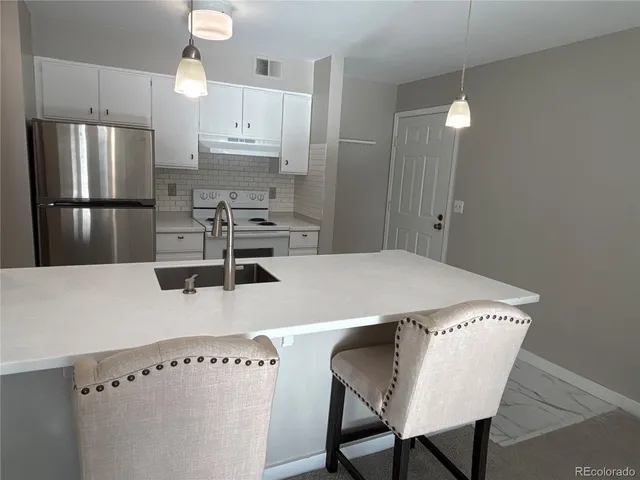 a kitchen with stainless steel appliances a table chairs and microwave