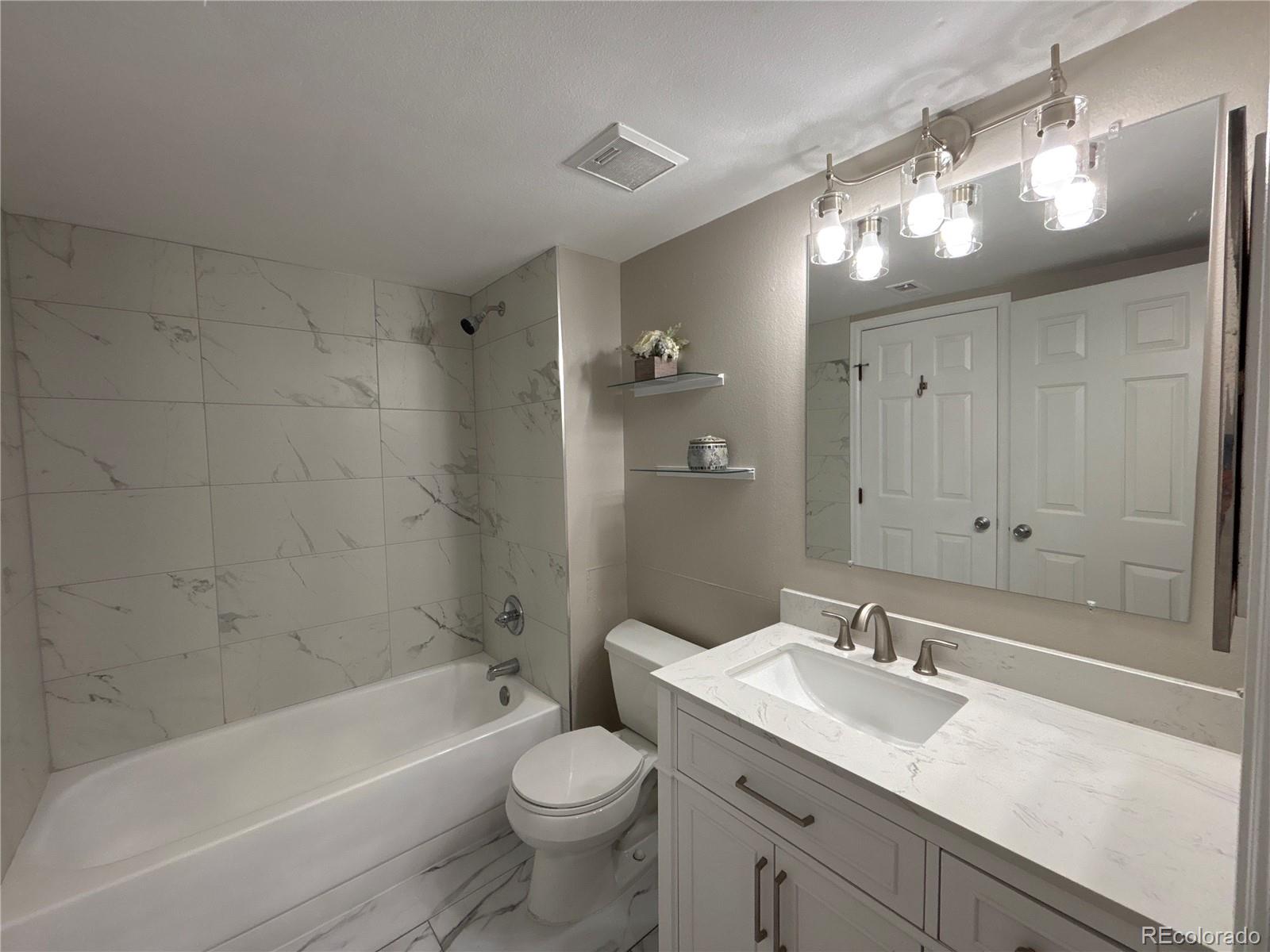 2575 South Syracuse Way, Unit J102 Denver, CO 80231 - Photo 7 of 13 a bathroom with a sink a toilet and shower