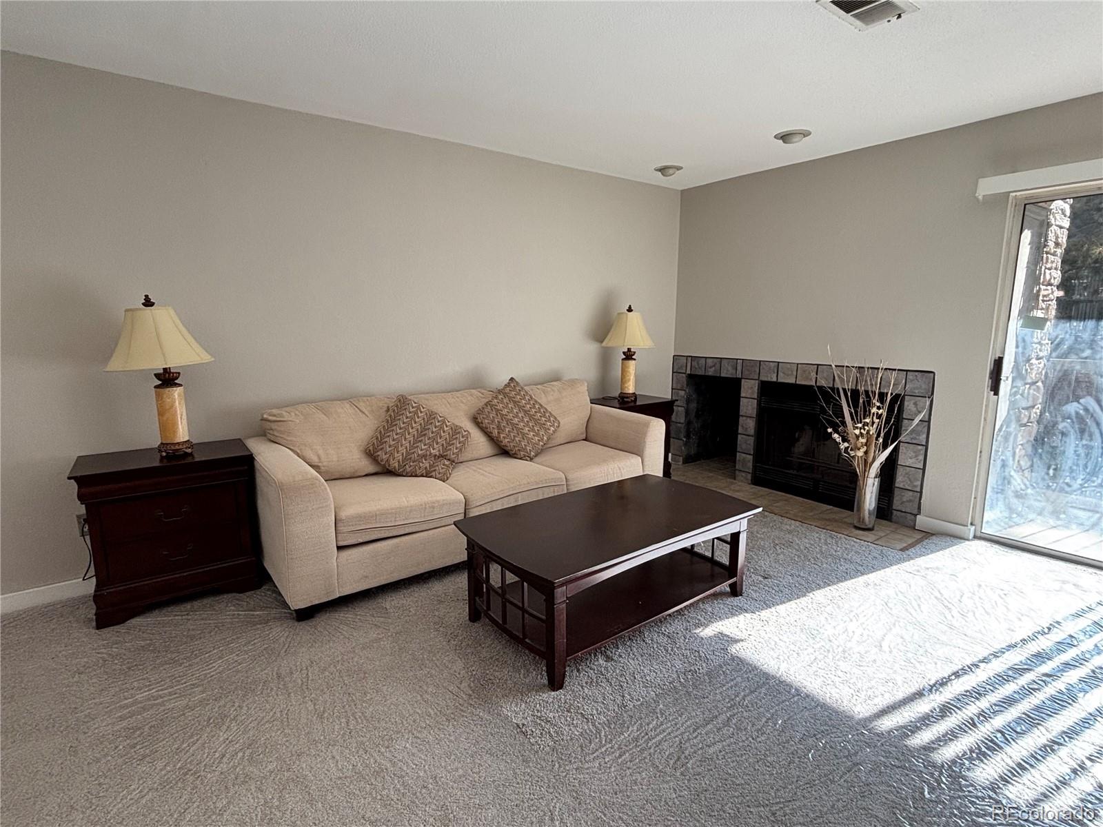 2575 South Syracuse Way, Unit J102 Denver, CO 80231 - Photo 8 of 13 a living room with furniture and a fireplace