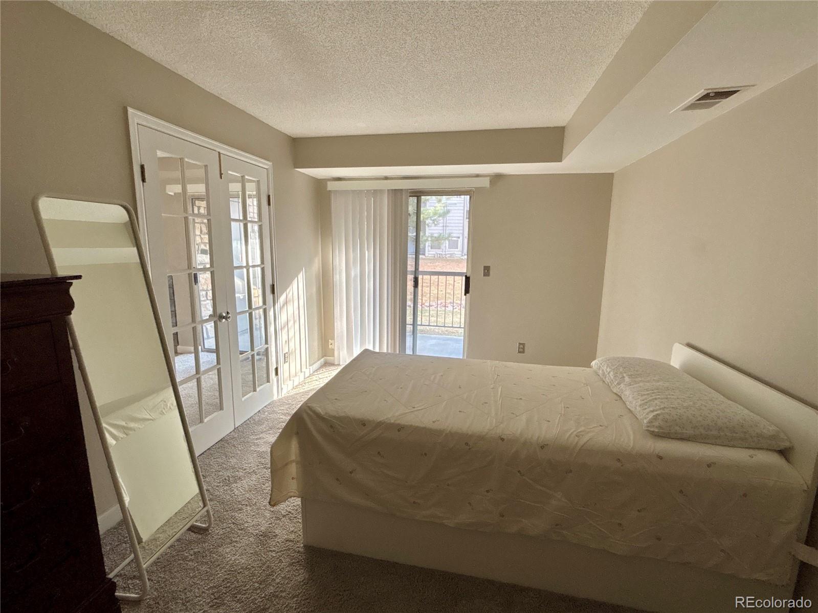 2575 South Syracuse Way, Unit J102 Denver, CO 80231 - Photo 9 of 13 a bedroom with a bed and large window