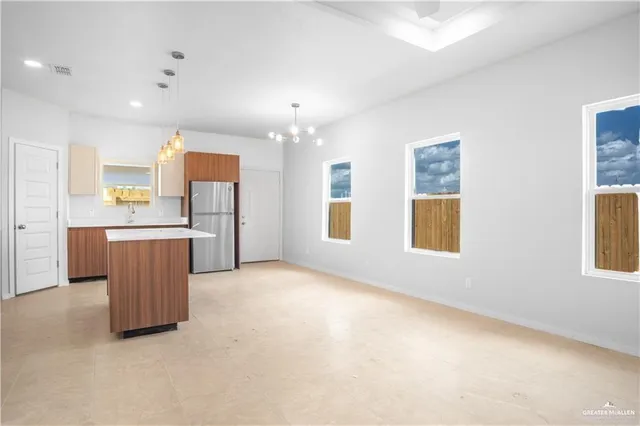 a kitchen with granite countertop a refrigerator a sink and a stove