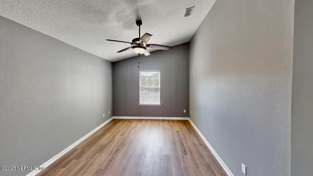 a view of room with a ceiling fan window and a ceiling fan