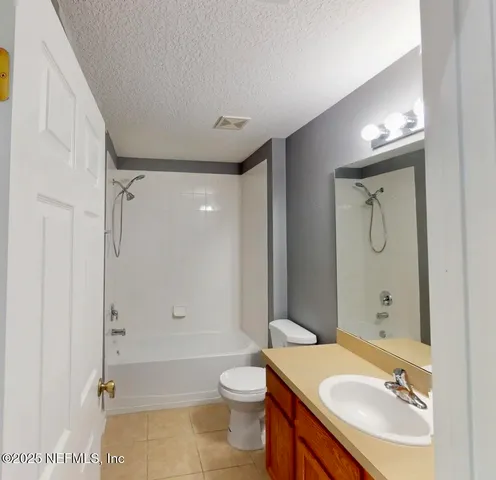 a bathroom with a granite countertop sink toilet mirror and shower