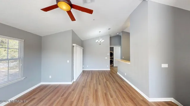 a view of a hallway with wooden floor and a chandelier