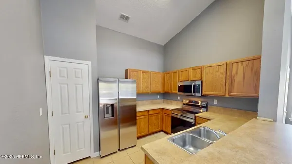a kitchen with granite countertop a refrigerator and a stove top oven