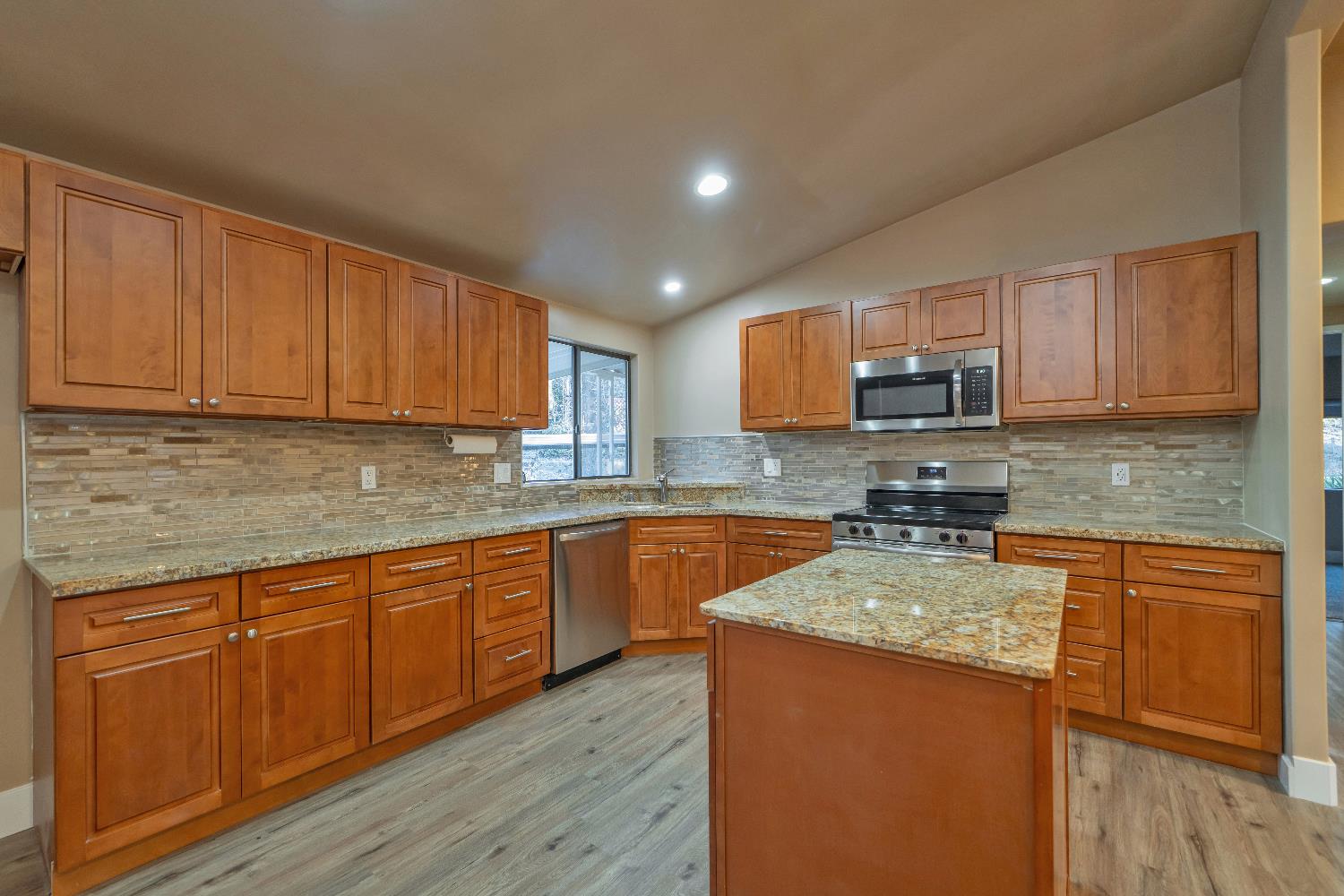 4420 Pleasant Valley Road, Unit 155 Diamond Springs, CA 95619 - Photo 13 of 42 a kitchen with stainless steel appliances granite countertop wooden cabinets a stove top oven a sink and dishwasher with wooden floor