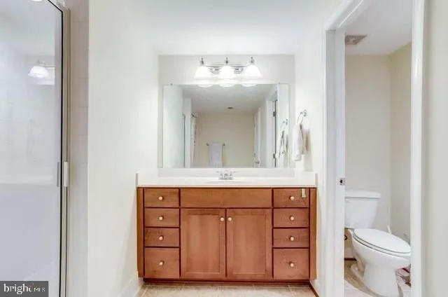 a bathroom with a sink vanity and a toilet