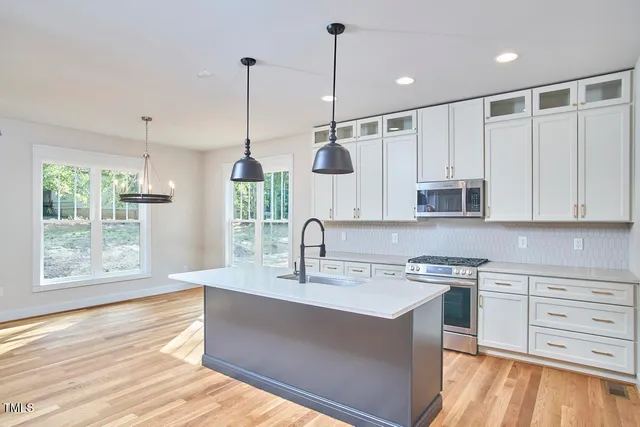 a kitchen with kitchen island white cabinets and black stainless steel appliances