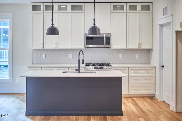a kitchen with stainless steel appliances granite countertop a sink a stove and a refrigerator