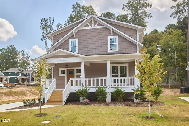 an aerial view of a house with a yard and large trees