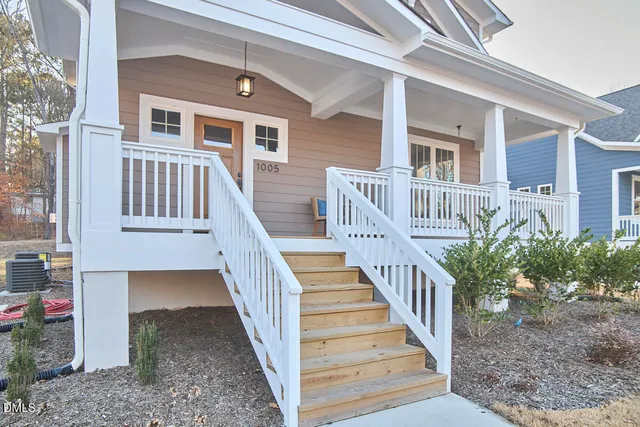 a living room with stainless steel appliances furniture and a kitchen view